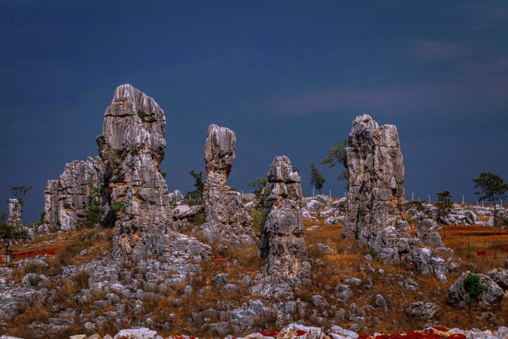 Formaciones rocosas del Bosque de Piedra de Shilin, en la provincia de Yunnan, China, con imponentes pilares de piedra caliza bajo un cielo oscuro.